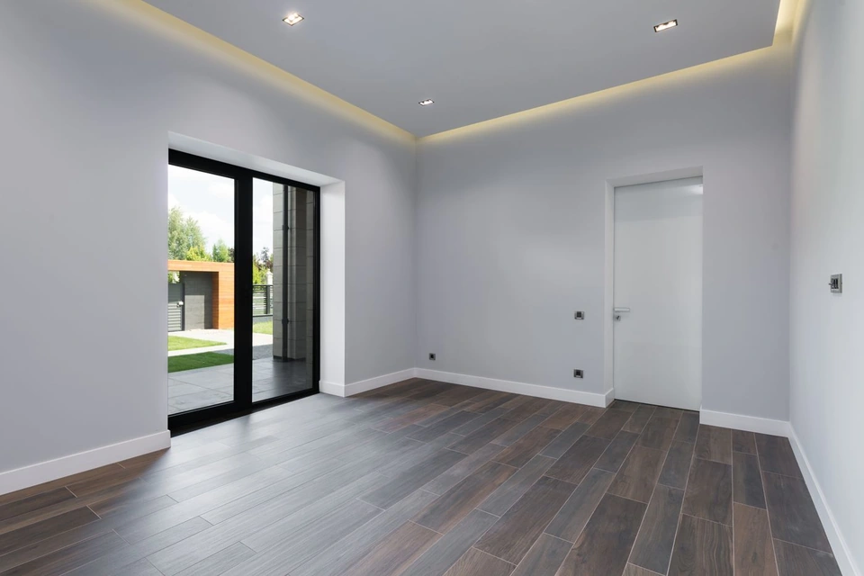 Ruime lege kamer met strak afgewerkte lichte wanden en een glazen pui