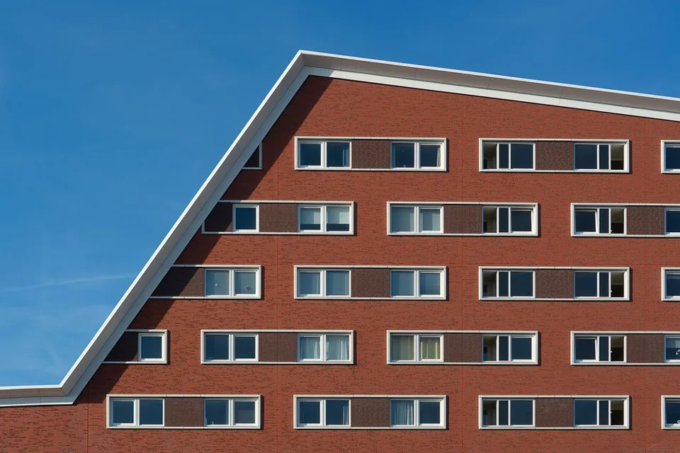 Nieuw woongebouw van rode baksteen met een schuin aflopend dak